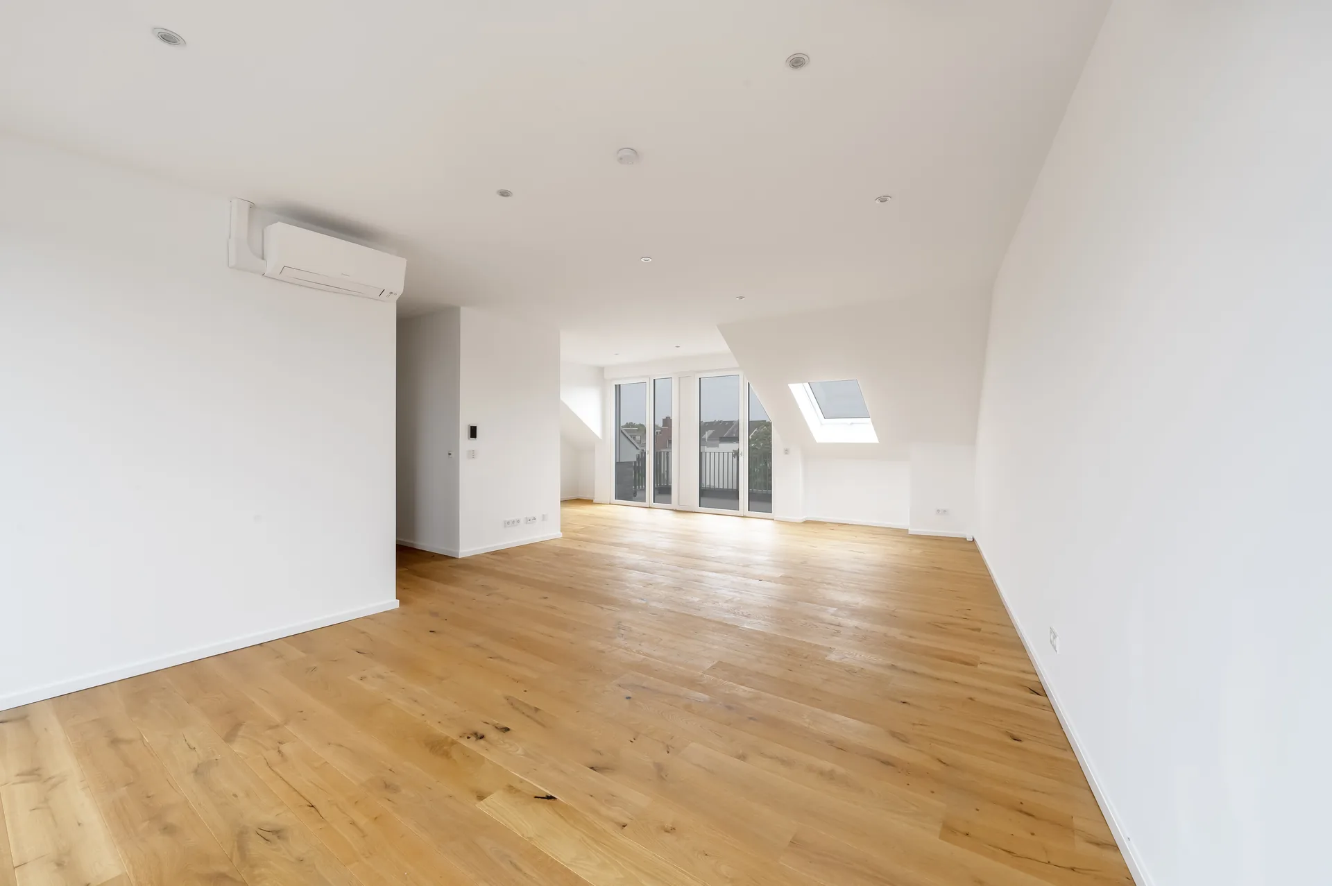 Weitläufiges Penthouse-Wohnzimmer mit Dachschräge, Klimaanlage und Balkonzugang im Luxus-Apartment, Quartier am Wasserturm Mönchengladbach